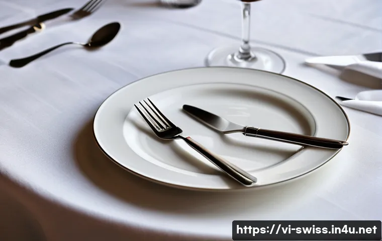 스위스에서 팁 문화와 식사 매너 - A refined Swiss dining table scene showing a neatly set plate with a fork and knife positioned paral...