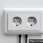 스위스의 전기 콘센트 규격 - A detailed close-up view of a Swiss Type J electrical outlet featuring three round pins with a centr...